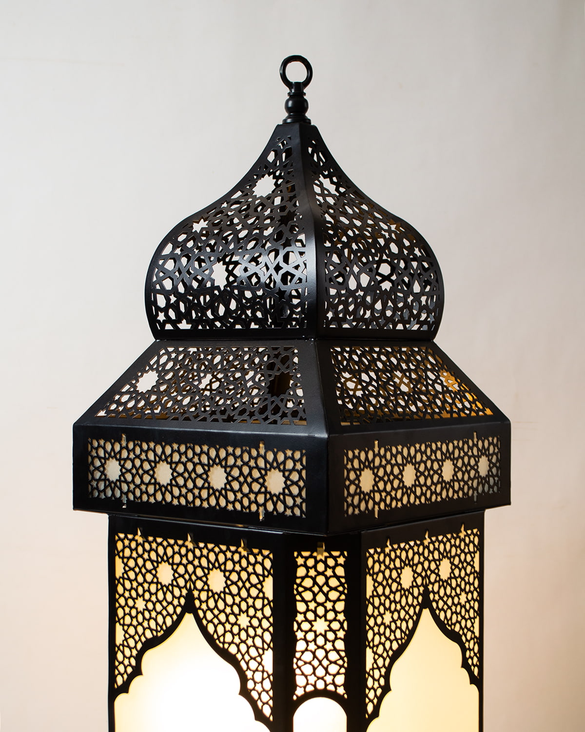 Decorative black ramdan lantern with intricate patterns on a light background