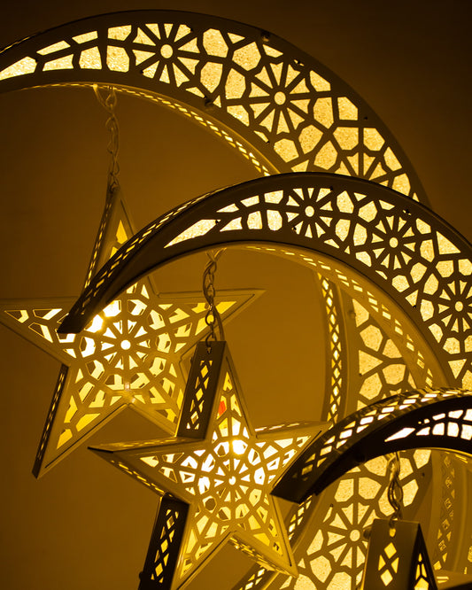 Decorative lanterns shaped like a star and crescent moon with intricate patterns, glowing warmly.