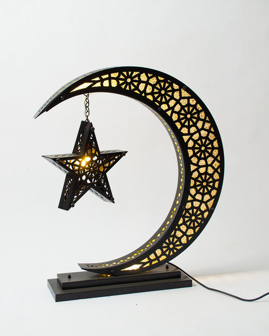 Decorative lamp shaped like a crescent moon with a star, featuring intricate patterns on a white background.