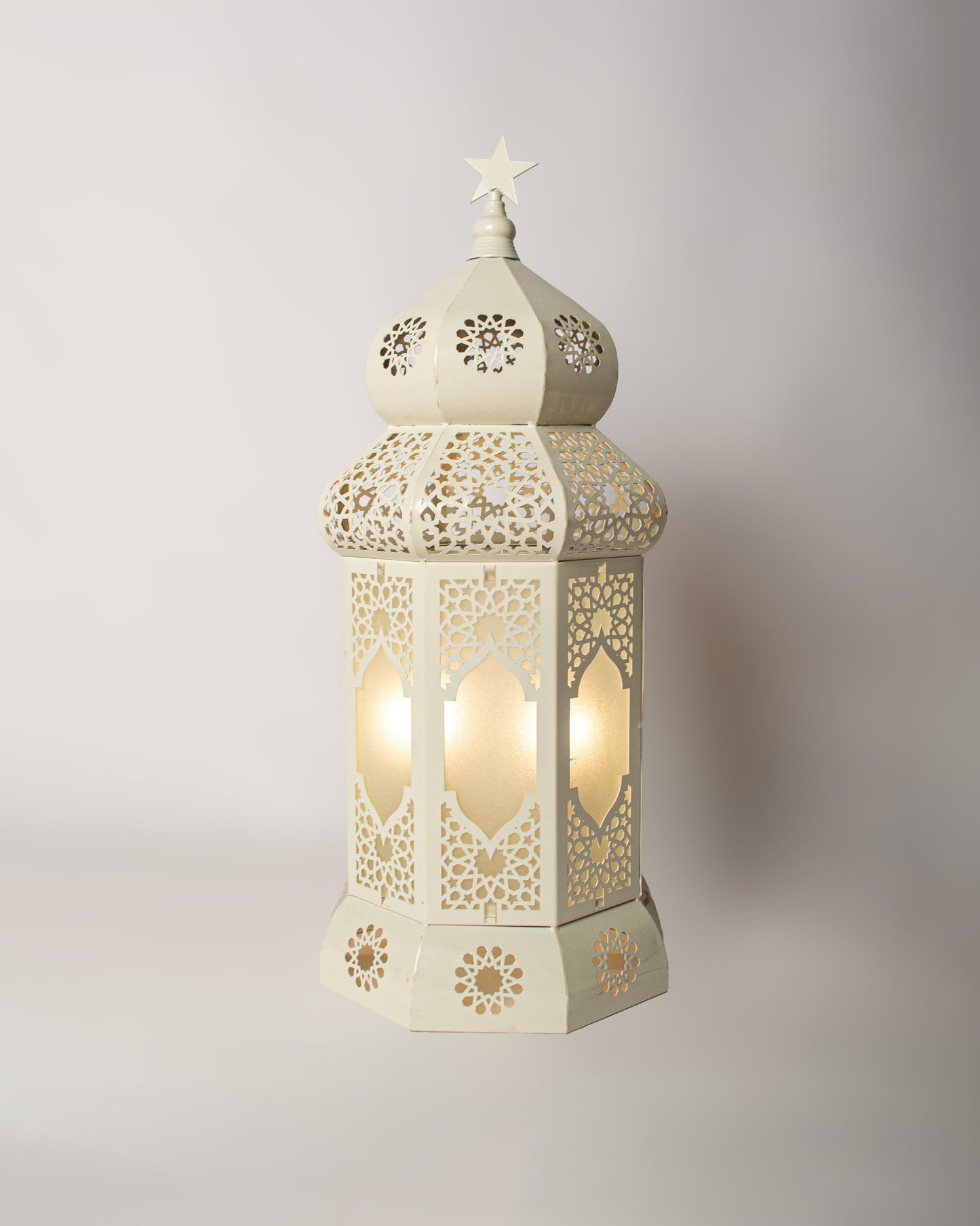 Decorative  Ramadan lantern with intricate cut-out patterns on a light gray background