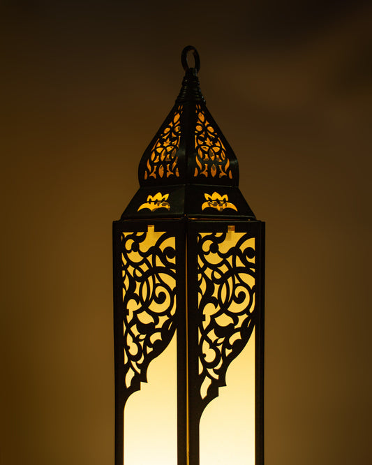 Decorative Ramadan  lantern with intricate cut-out patterns on a dark background