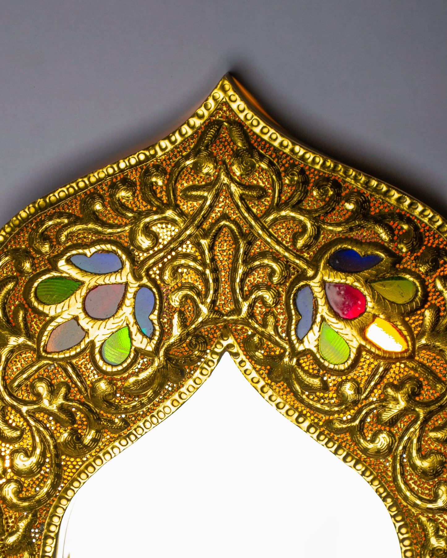 zoom in on a top border of a decorative light up mirror with glass inlay 