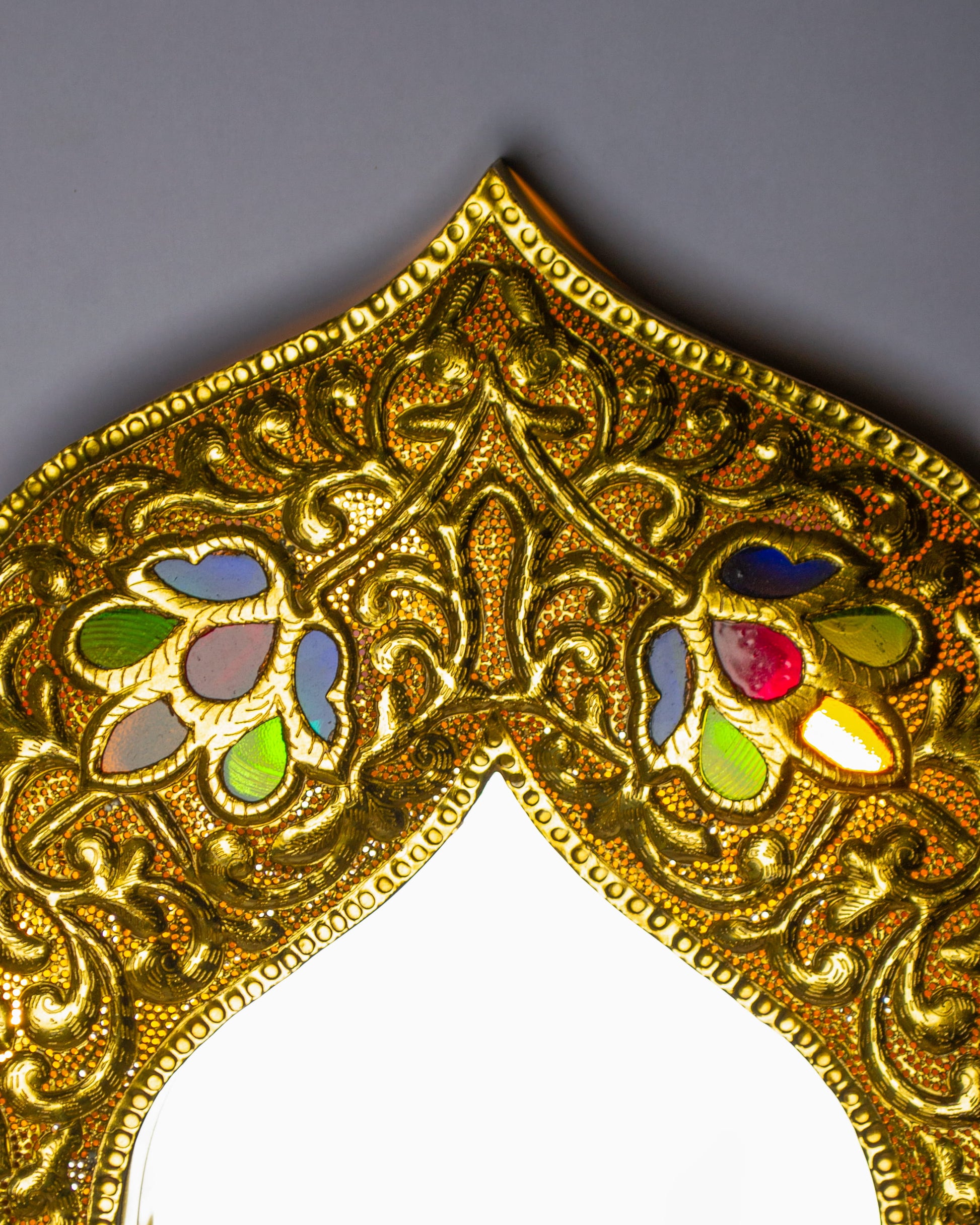 zoom in on a top border of a decorative light up mirror with glass inlay 